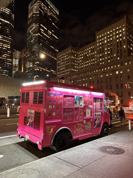 Pink food truck at night downtown